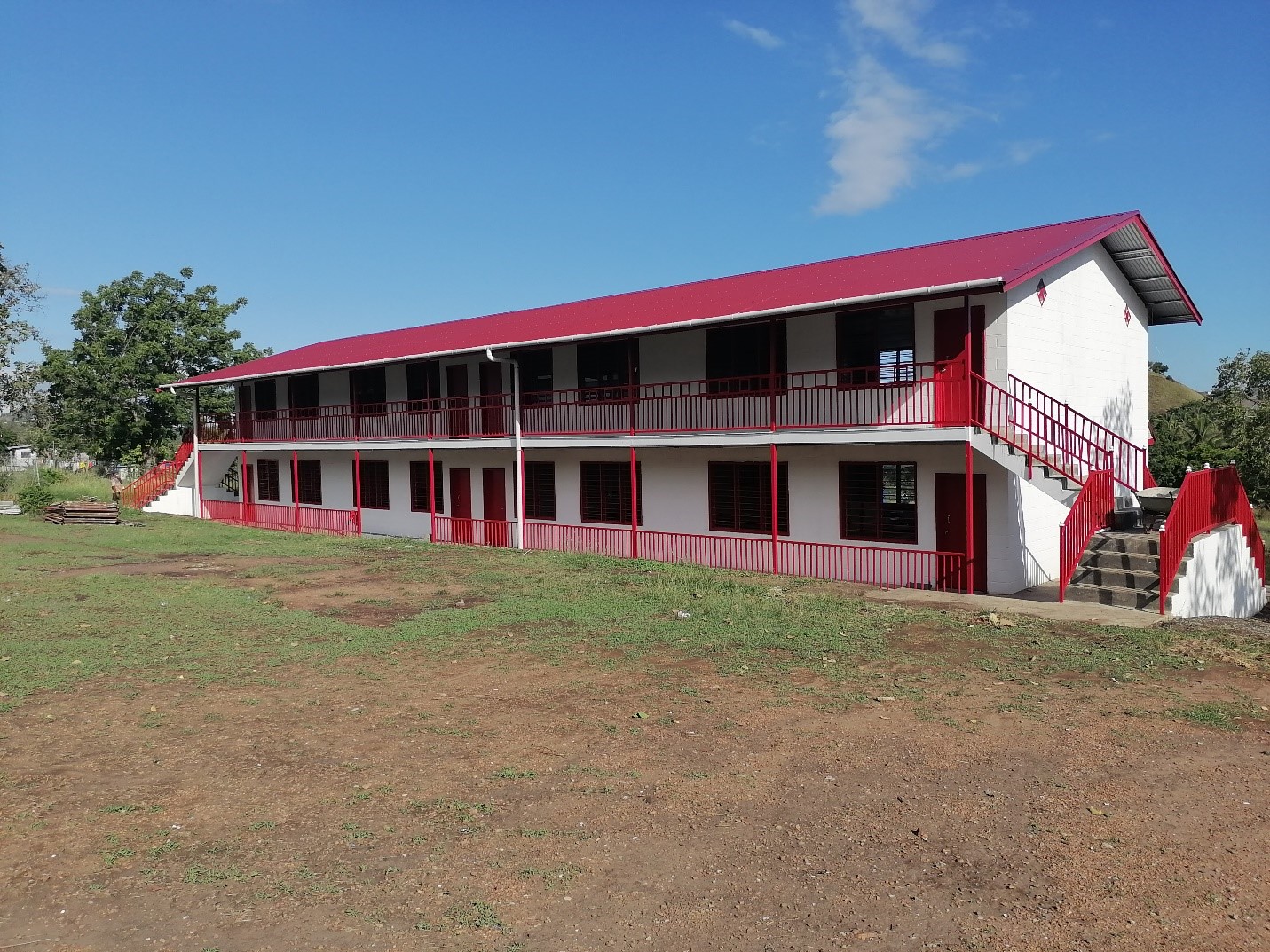 A school building, with white walls and a red roof