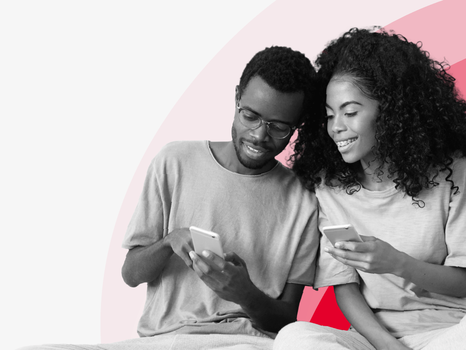 A couple smiling, looking at a phone