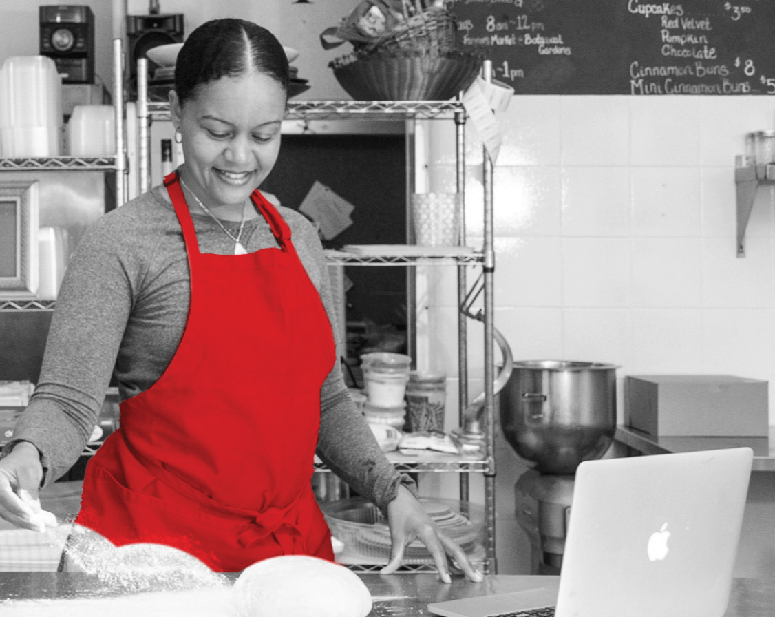 Woman cooking with computer in front of her