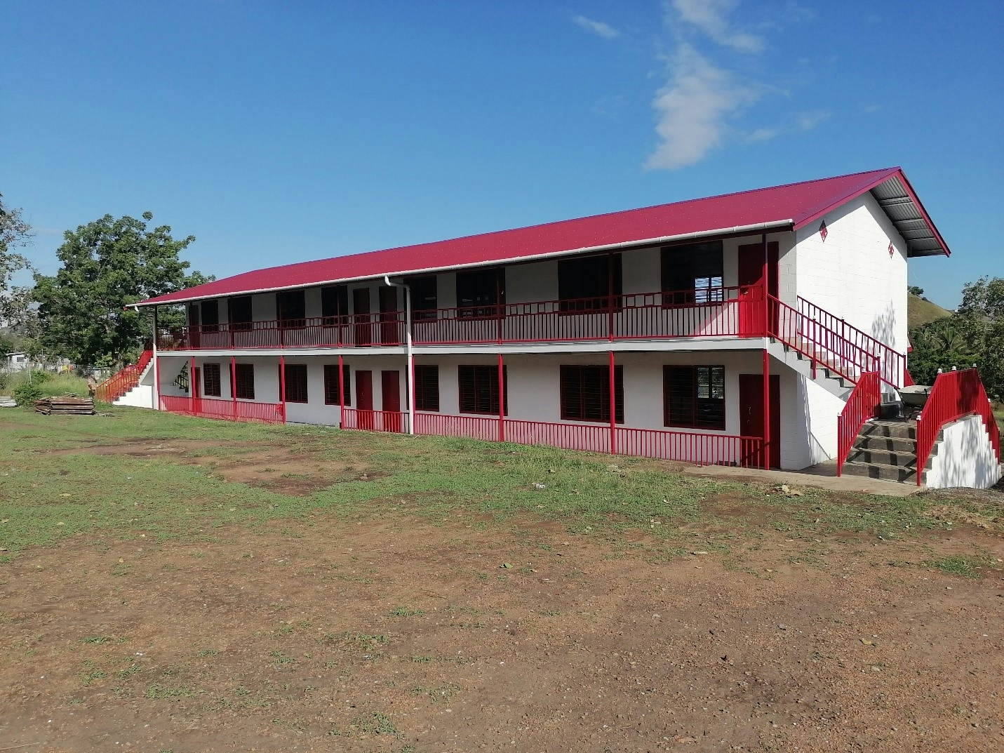 A school building, with white walls and a red roof